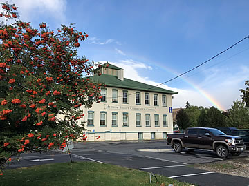 MV Community Center with a rainbow in the background on a sunny day.