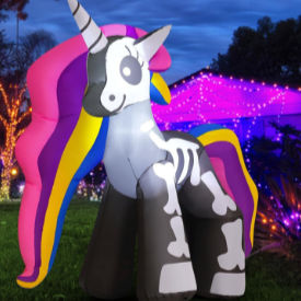 Bright rainbow-colored large blowup unicorn with its skeleton on display.